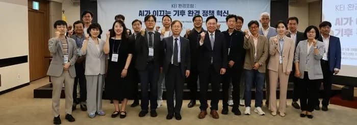 ‘KEI 환경포럼: AI가 이끄는 기후 환경 정책 혁신’ 현수막 앞에서 주먹을 들어 보이며 함께 선 포럼 참석자들의 단체 사진