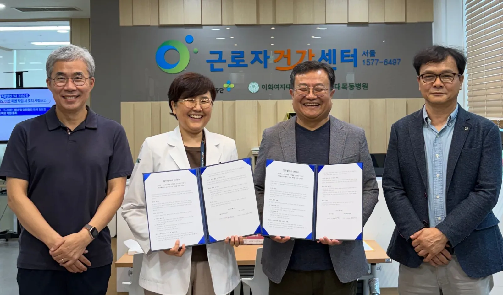 서울근로자건강센터에서 업무협약서를 펼쳐 들고 함께 선 참석자 네 명