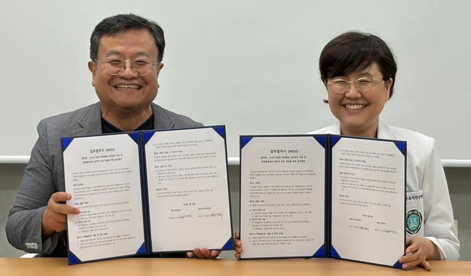 The CEO of PicChem Inc. and the director of the Seoul Workers' Health Center holding the MOU documents